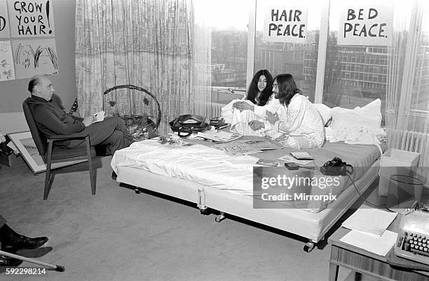 Pictured on their "honeymoon" bed newly weds. John Lennon and Yoko talking to Donald Zec about their seven day event at the Amsterdam Hilton Hotel....