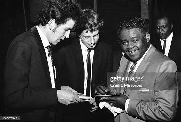 American rock and roll star Fats Domino signs autographs for fans on the stage of the Saville Theatre in London as he prepares for the evening show...