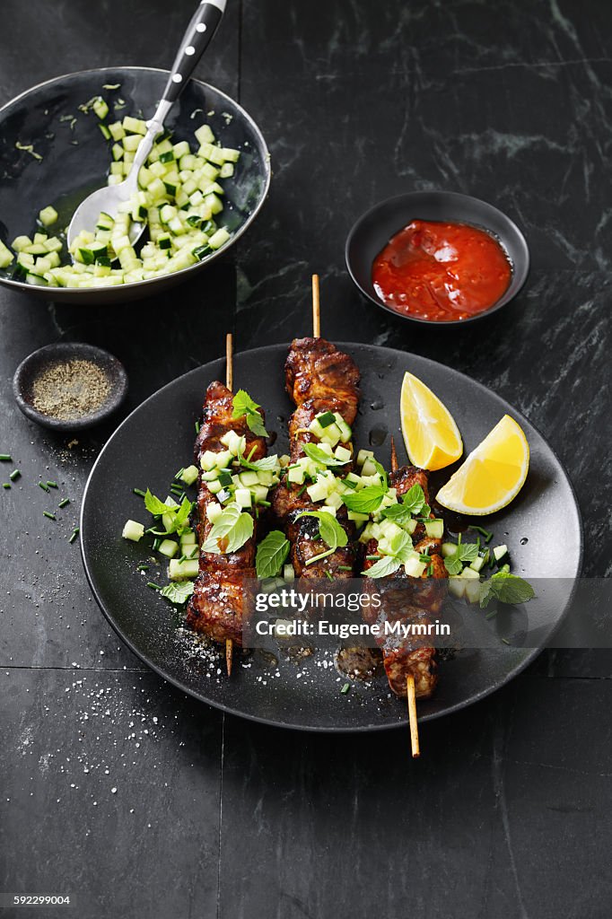 Pork belly skewers with cucumber salad