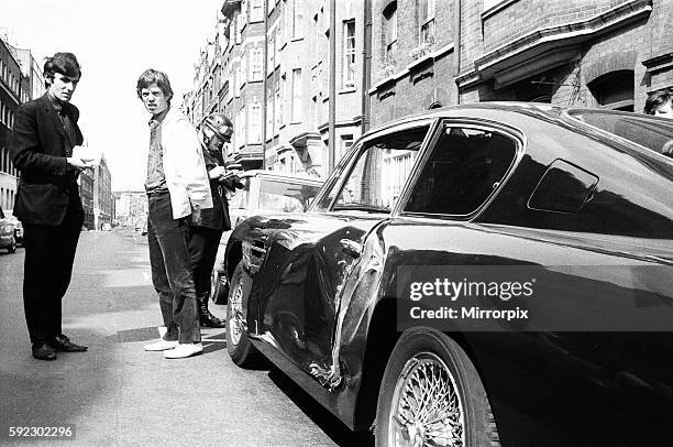 Jagger's Girlfriend Chrissie Shrimpton looks on as Mick has his particulars taken by a patrolman.r 1966.