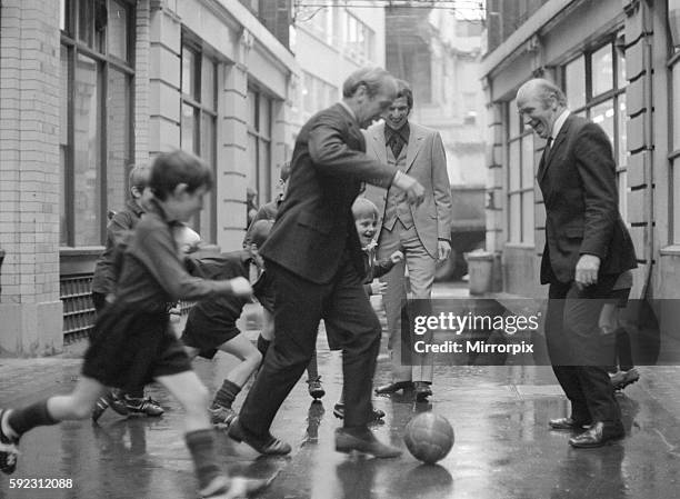 Manchester United and England footballer Bobby Charlton is chased in the street by children of Dounside Purley School in Surrey watched by England...