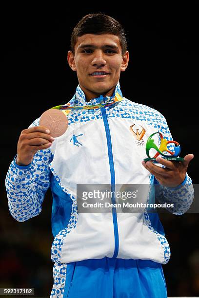 Bronze medalist Murodjon Akhmadaliev of Uzbekistan poses during the medal ceremony for the Men's Bantam on Day 15 of the Rio 2016 Olympic Games at...