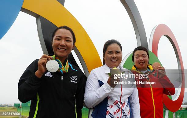 Silver medalist, Lydia Ko of New Zealand, gold medalist, Inbee Park of Korea and bronze medalist Shanshan Feng of China pose by the olympic rings...