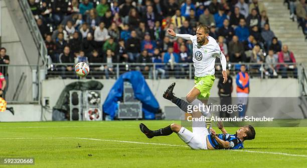 Bas Dost of VfL Wolfsburg scores the second goal for his team against Christopher Schorch of FSV Frankfurt during the DFB Cup match between FSV...