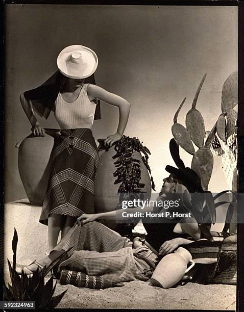 Models wearing white knit hat with net mantilla, white maillot, and Spanish plaid skirt, all by Schiaparelli; and scarlet mantilla on blue hat, blue...