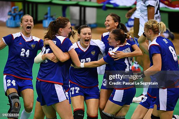 Players of Russia celebrate their victory during the women's Gold Medal handball match France vs Russia for the Rio 2016 Olympics Games at the Future...