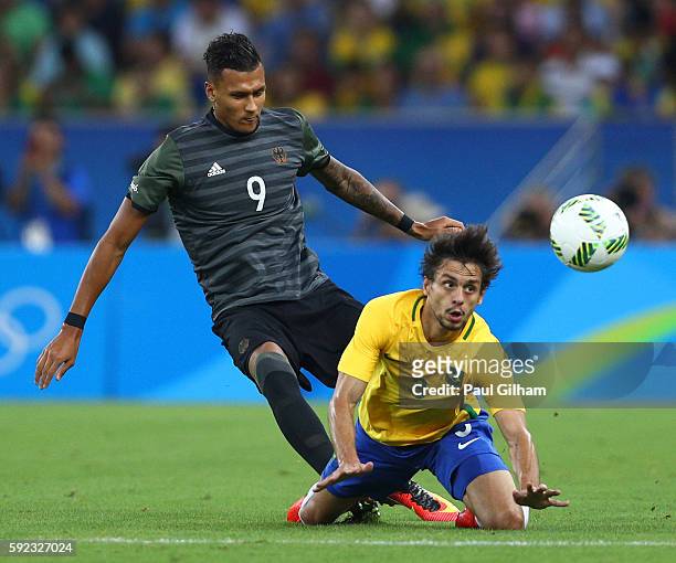 Davie Selke of Germany challenges Rodrigo Caio of Brazil during the Men's Football Final between Brazil and Germany at the Maracana Stadium on Day 15...