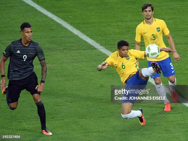 Brazil's defender Douglas Santos controls the ball next to Brazil's defender Rodrigo Caio and Germany's forward Davie Selke during the Rio 2016...