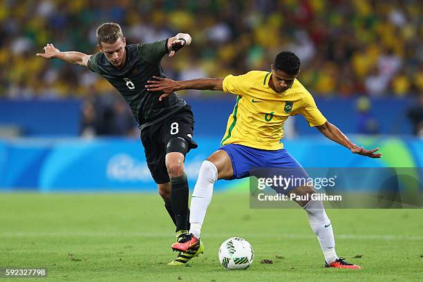 Lars Bender of Germany and Douglas Santos of Brazil challenge for the ball during the Men's Football Final between Brazil and Germany at the Maracana...