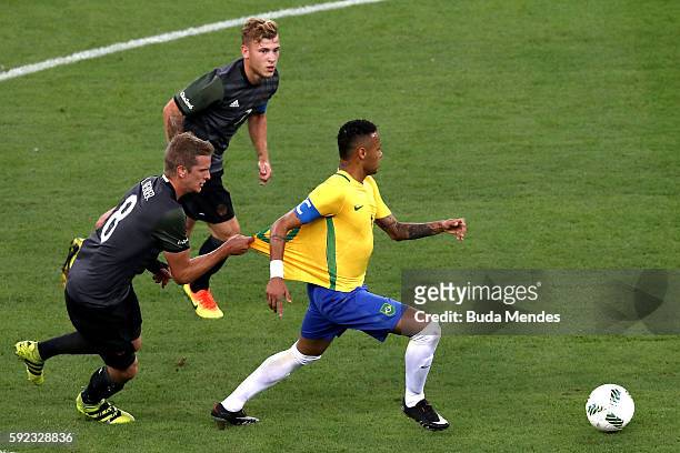 Neymar of Brazil has his shirt pulled by Lars Bender of Germany during the Men's Football Final between Brazil and Germany at the Maracana Stadium on...