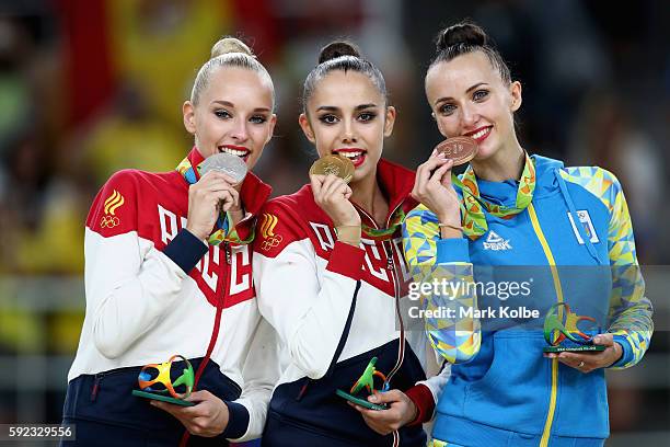 Silver medalist Yana Kudryavtseva of Russia, gold medalist Margarita Mamun of Russia and bronze medalist Ganna Rizatdinova of Ukraine celebrate on...