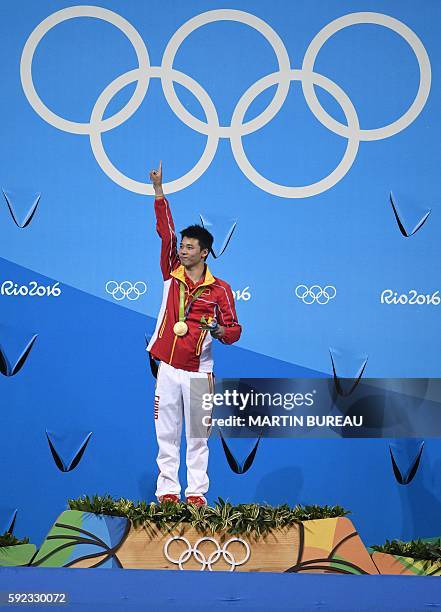 Gold medallist China's Chen Aisen celebrates during the podium ceremony of the Men's 10m Platform final during the diving event at the Rio 2016...