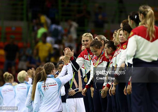 Bronze medalists of Norway congratulate gold medalists of Russia during the medal ceremony for the Women's Handball contest following the Women's...