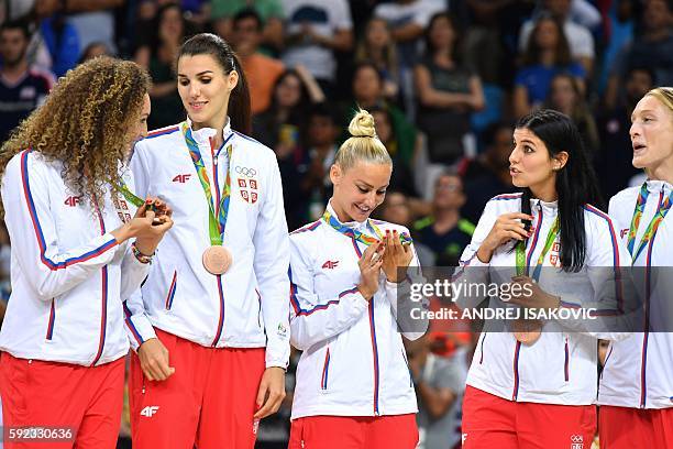 Serbia's point guard Milica Dabovic looks at her bronze medal with teammates after the final of the Women's basketball competition at the Carioca...