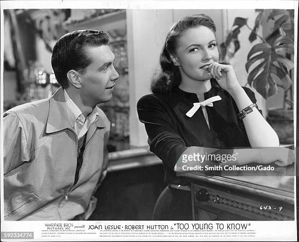 Movie still scene from "Too Young To Know" , a Warner Bros Pictures production, showing a young man trying to amuse a young lady, 1945. .