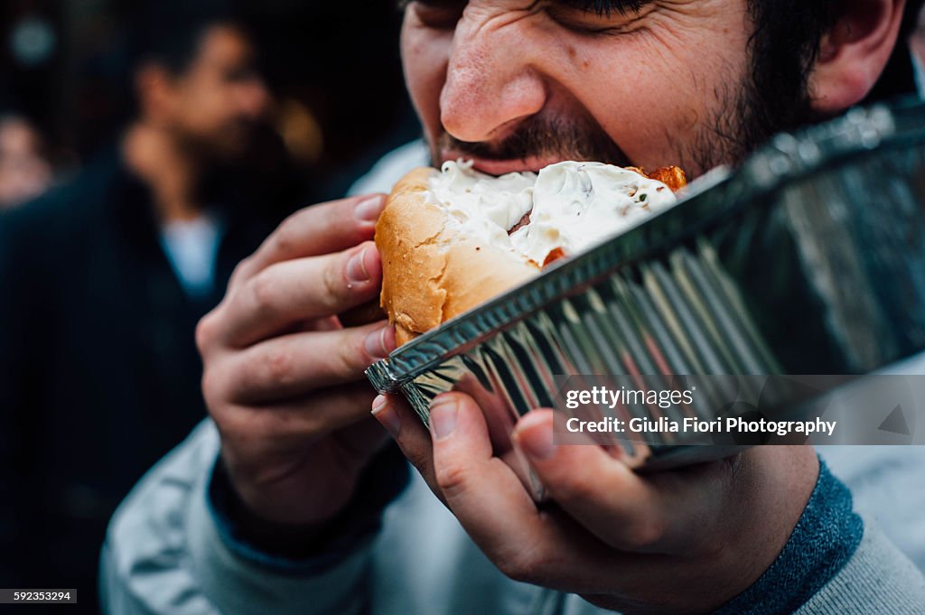 Man eating hot dog on the streets