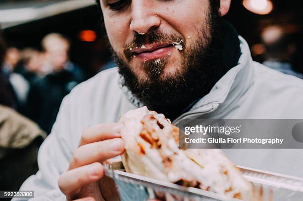 man eating hot dog on the streets - borough market stock pictures, royalty-free photos & images