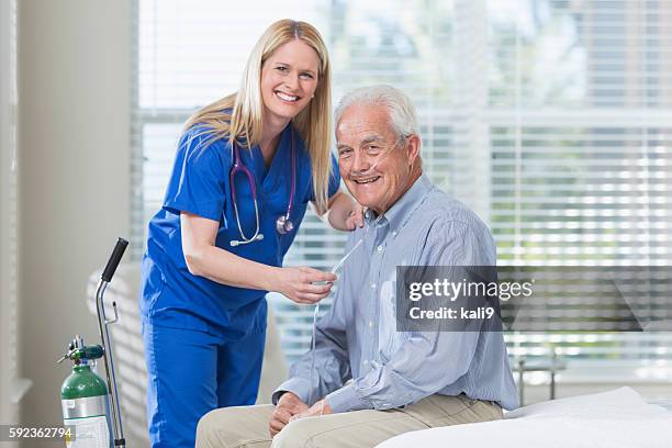 home healthcare nurse helping elderly man with oxygen - medical oxygen equipment 個照片及圖片檔