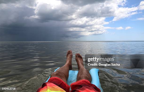 inflatable raft in the open water with a approching storm - castaway island fiji stockfoto's en -beelden