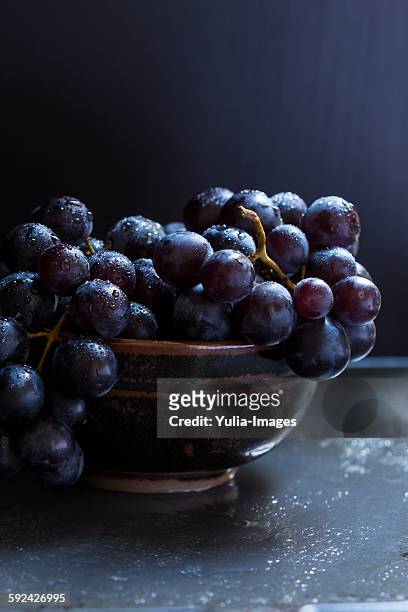 Bowl of juicy ripe black grapes