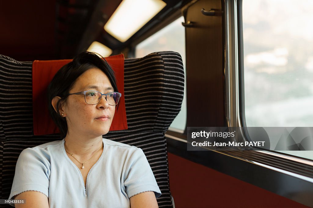Woman looking through window in a train