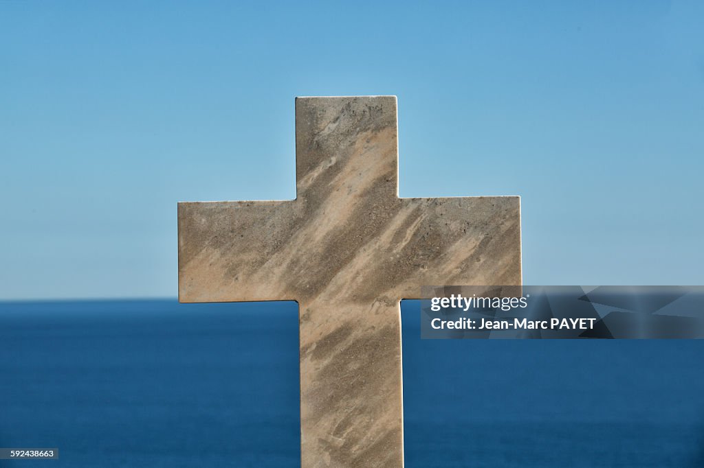 Cross in cemetery above the horizon and the sea