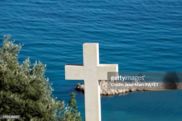 white cross in cemetery above the sea - jean marc payet stock-fotos und bilder