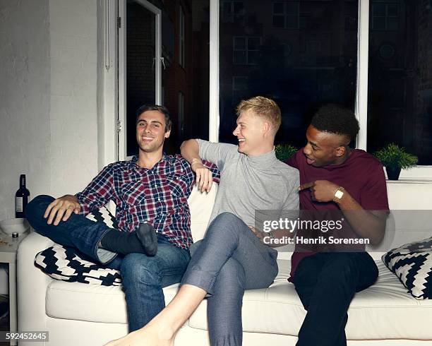 group of young people having a party - three people on couch stock pictures, royalty-free photos & images