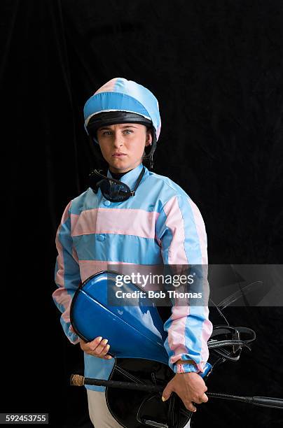 female jockey with saddle and helmet - jockey stock pictures, royalty-free photos & images