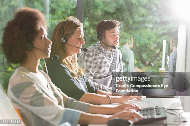 business people wearing headsets in office - sunny office stock pictures, royalty-free photos & images