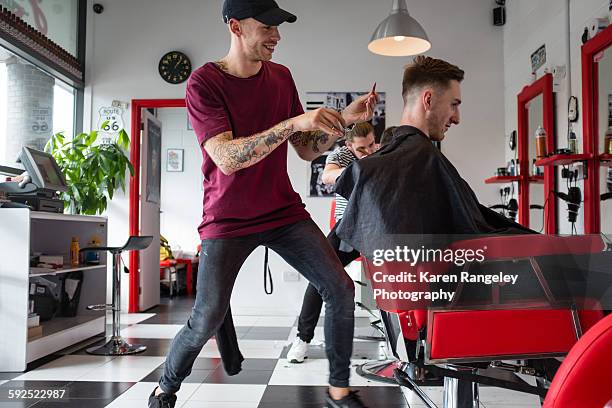 Barber Will enjoying his work as he trims client Alex's hair in the salon