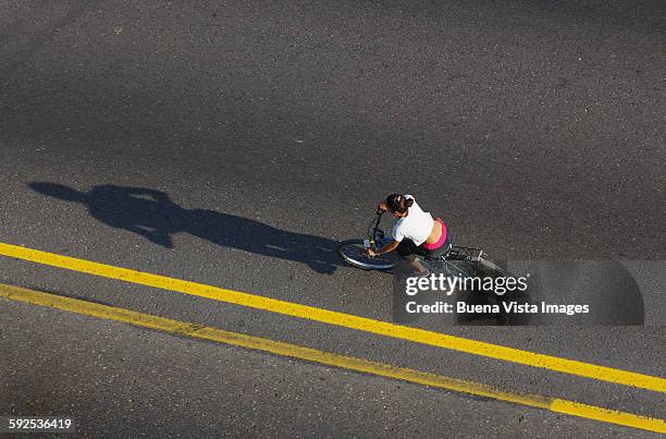 woman on bicycle on a street of havana - yellow line stockfoto's en -beelden