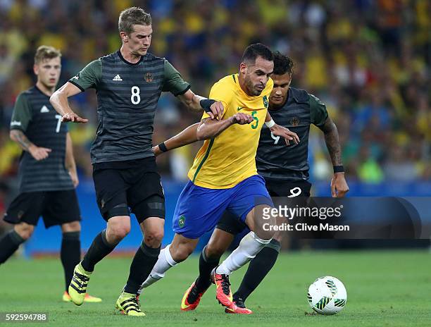 Renato Augusto of Brazil holds off the challenge of Lars Bender of Germany and Davie Selke of Germany during the Men's Football Final between Brazil...