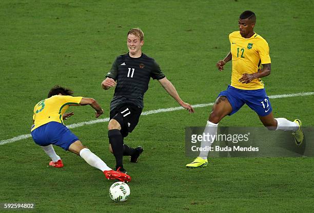 Julian Brandt of Germany is challenged by Rodrigo Caio of Brazil during the Men's Football Final between Brazil and Germany at the Maracana Stadium...