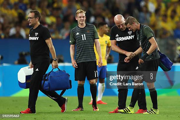 Lars Bender of Germany is attended to by medical staff during the Men's Football Final between Brazil and Germany at the Maracana Stadium on Day 15...