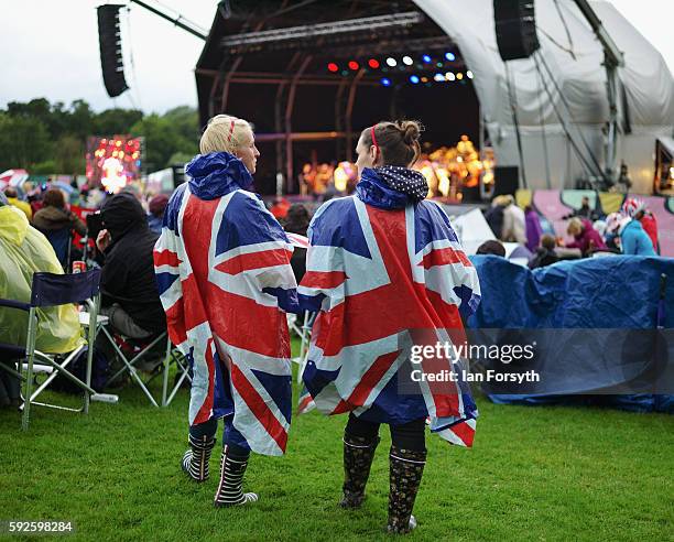 Spectators wearing Union Flag ponchos stand in the rain watching the performance at the annual classical Proms Spectacular concert held on the north...