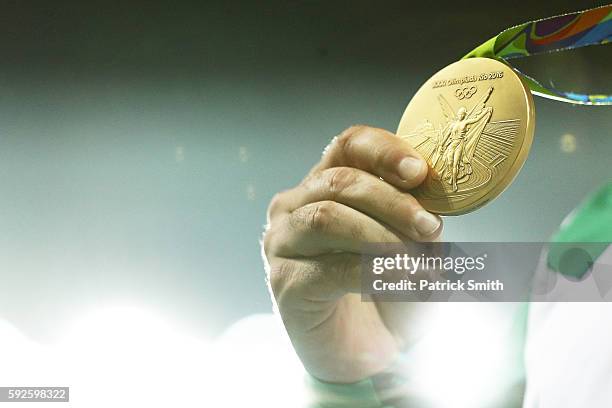 Gold medalist Dilshod Nazarov of Tajikistan shows his medal during the medal ceremony for the Men's Hammer Throw on Day 15 of the Rio 2016 Olympic...