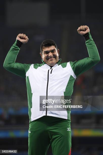 Gold medallist Tajikistan's Dilshod Nazarov stands on the podium during the medal ceremony for the Men's hammer throw final during the athletics at...