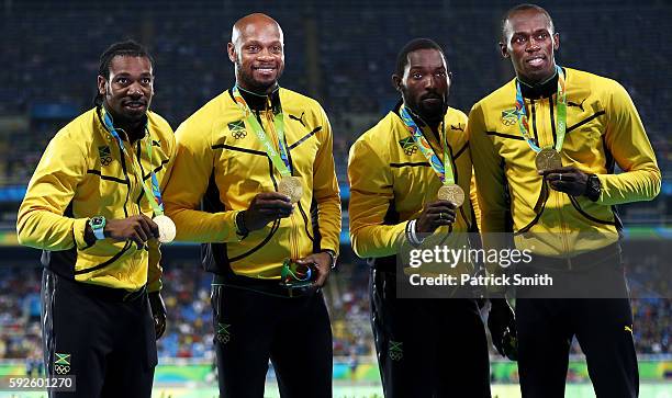 Gold medalists Asafa Powell, Yohan Blake, Nickel Ashmeade and Usain Bolt of Jamaica stand on the podium during the medal ceremony for the Men's 4 x...