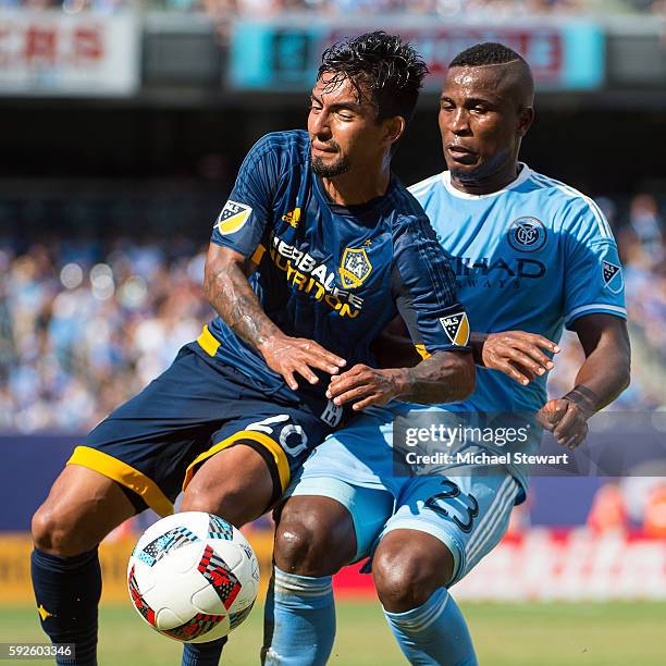 Defenders Jefferson Mena of New York City FC and A. J. DeLaGarza of Los Angeles Galaxy vie for the ball during the match at Yankee Stadium on August...