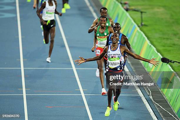 Mohamed Farah of Great Britain reacts after winning gold in front of Paul Kipkemoi Chelimo of the United States in the Men's 5000 meter on Day 15 of...