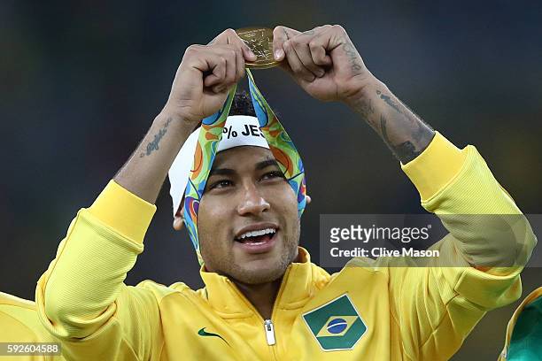 Neymar of Brazil celebrates with his gold medal following the Men's Football Final between Brazil and Germany at the Maracana Stadium on Day 15 of...
