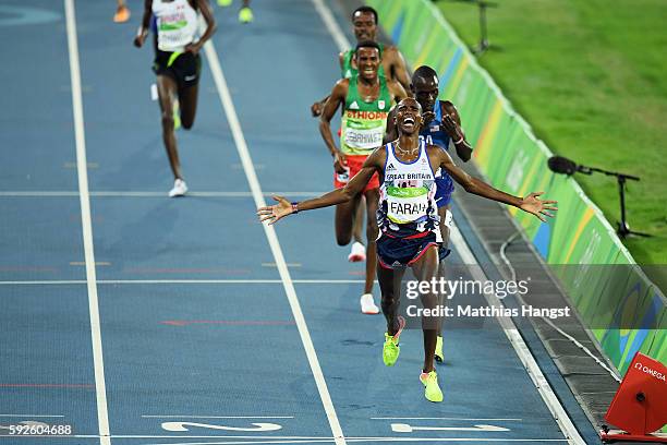 Mohamed Farah of Great Britain reacts after winning gold in front of Paul Kipkemoi Chelimo of the United States in the Men's 5000 meter on Day 15 of...