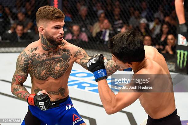 Cody Garbrandt punches Takeya Mizugaki of Japan in their bantamweight bout during the UFC 202 event at T-Mobile Arena on August 20, 2016 in Las...
