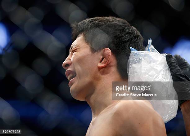 Takeya Mizugaki has ice applied to the back of his head after his first-round TKO loss to Cody Garbrandt in their bantamweight bout at the UFC 202...