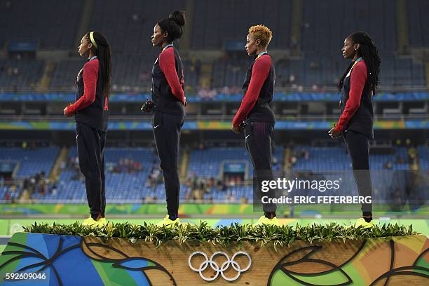 Gold medallist USA's Allyson Felix, USA's Phyllis Francis, USA's Natasha Hastings and USA's Courtney Okolo listen to their national anthem as they...