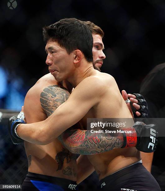 Cody Garbrandt and Takeya Mizugaki hug after their bantamweight bout at the UFC 202 event at T-Mobile Arena on August 20, 2016 in Las Vegas, Nevada....