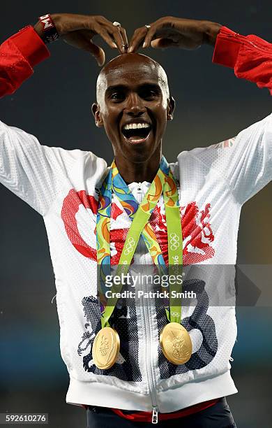 Gold medalist Mohamed Farah of Great Britain celebrates with both his 5000 meter and 10000 meter gold medals on the podium during the medal ceremony...