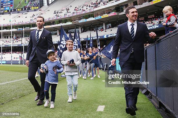 The retired Andrew Walker of the Blues and Michael Jamison walk a lap of honour during the round 22 AFL match between the Carlton Blues and the...