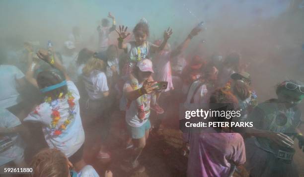 People participate in the annual Color Run after party in Centennial Park in Sydney on August 21, 2016. The Color Run is a 5km fun run started in the...